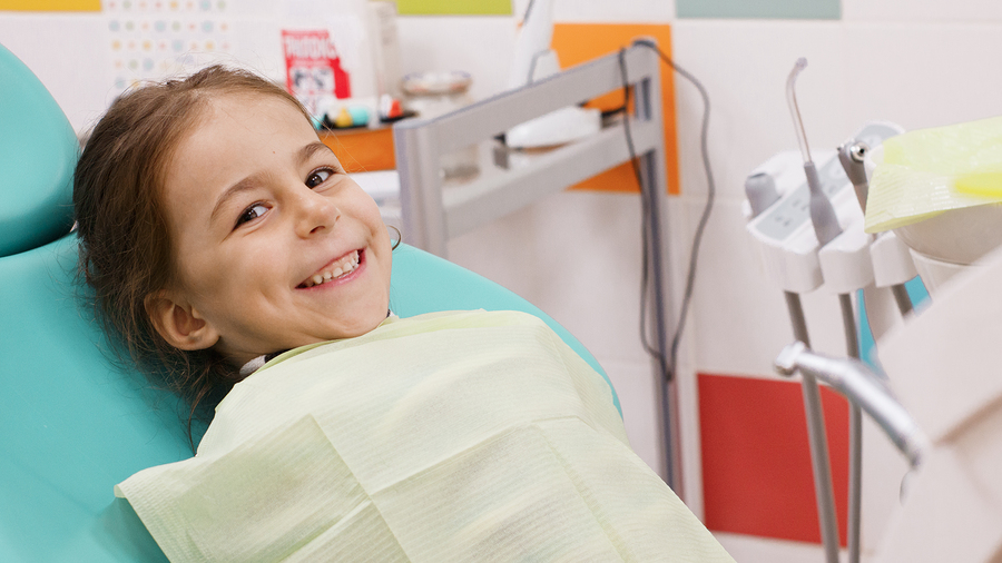 Happy child in a dentist\'s chair after dental treatment