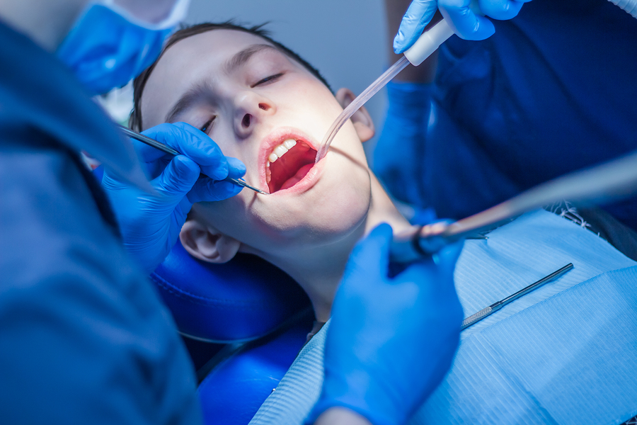 A teenager with an open mouth in dentistry at a dentist's appointment. Dental treatment.