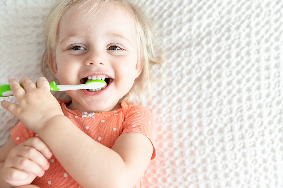 Cute Happy Baby Brushing Teeth and Smiling. Copy Space