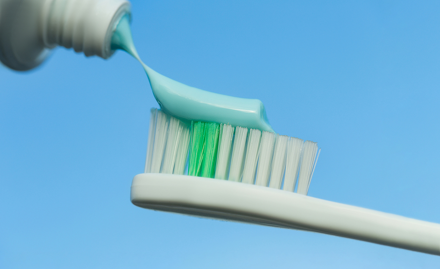 Toothbrush And Toothpaste On Blue Background. Toothpaste Squeeze